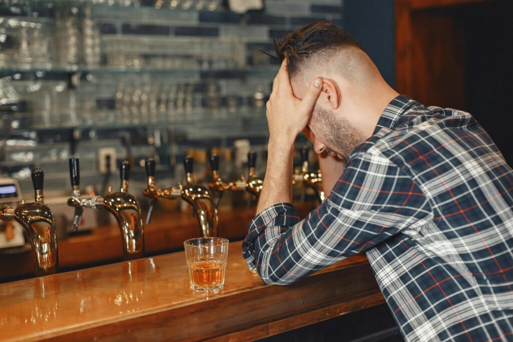 man struggling with gambling addiction and alcohol abuse alone