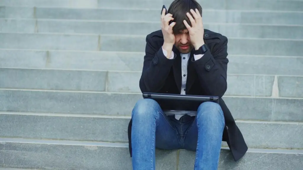 young man addicted to sports betting app on phone